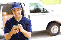 Man using tablet computer in front of his work van